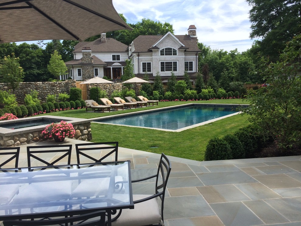 На фото: естественный, прямоугольный бассейн среднего размера на заднем дворе в классическом стиле с джакузи и покрытием из каменной брусчатки с