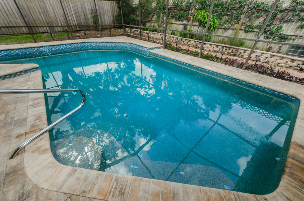 Esempio di una grande piscina naturale stile marinaro personalizzata dietro casa con pavimentazioni in mattoni