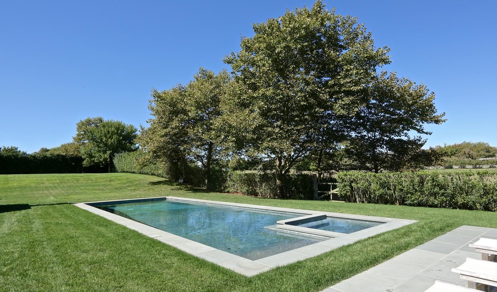 Пример оригинального дизайна: большой спортивный, прямоугольный бассейн на заднем дворе в классическом стиле с джакузи и мощением тротуарной плиткой