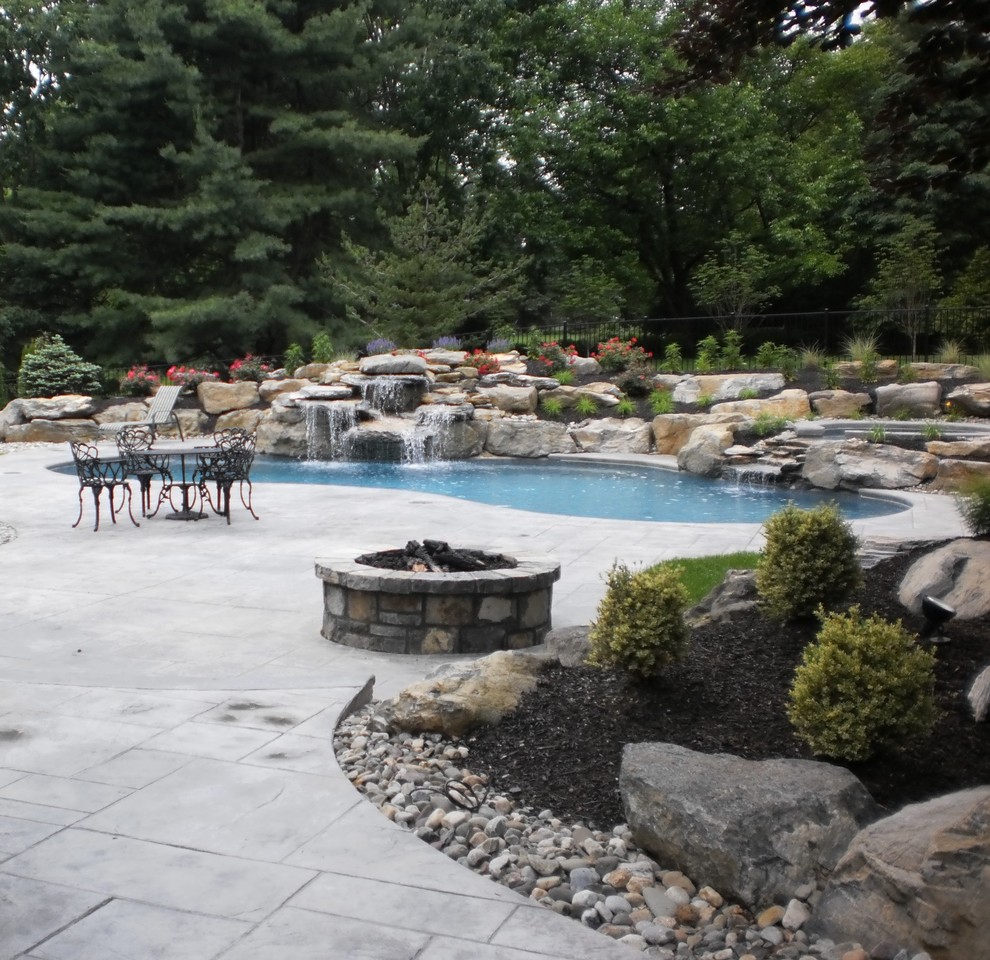 Idee per una piscina naturale chic personalizzata dietro casa con cemento stampato e una vasca idromassaggio
