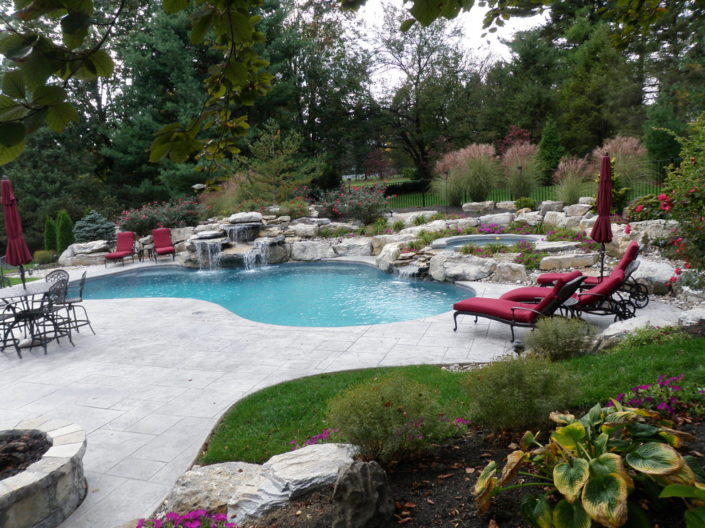Photo of a traditional back custom shaped natural hot tub in Philadelphia with stamped concrete.