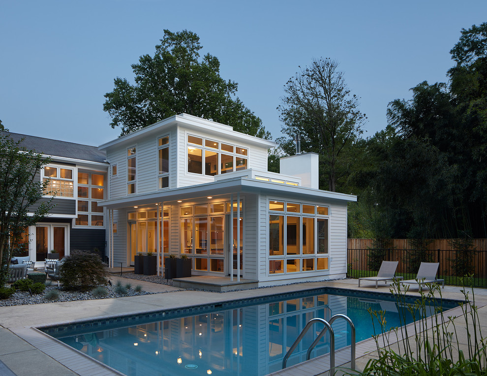 Esempio di una piscina monocorsia design rettangolare dietro casa con lastre di cemento