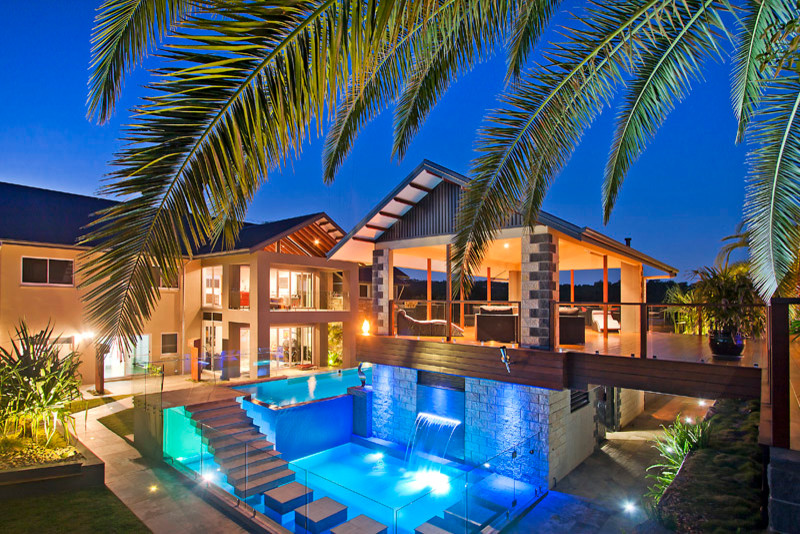 Foto de casa de la piscina y piscina elevada contemporánea grande en forma de L en patio trasero con suelo de baldosas
