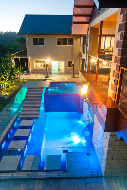 Inspiration for a large contemporary back l-shaped above ground swimming pool in Brisbane with a pool house and tiled flooring.
