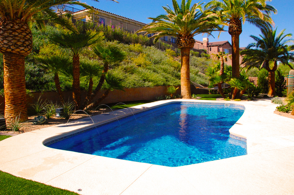 Imagen de piscina con fuente natural tradicional de tamaño medio en forma de L en patio trasero con suelo de hormigón estampado