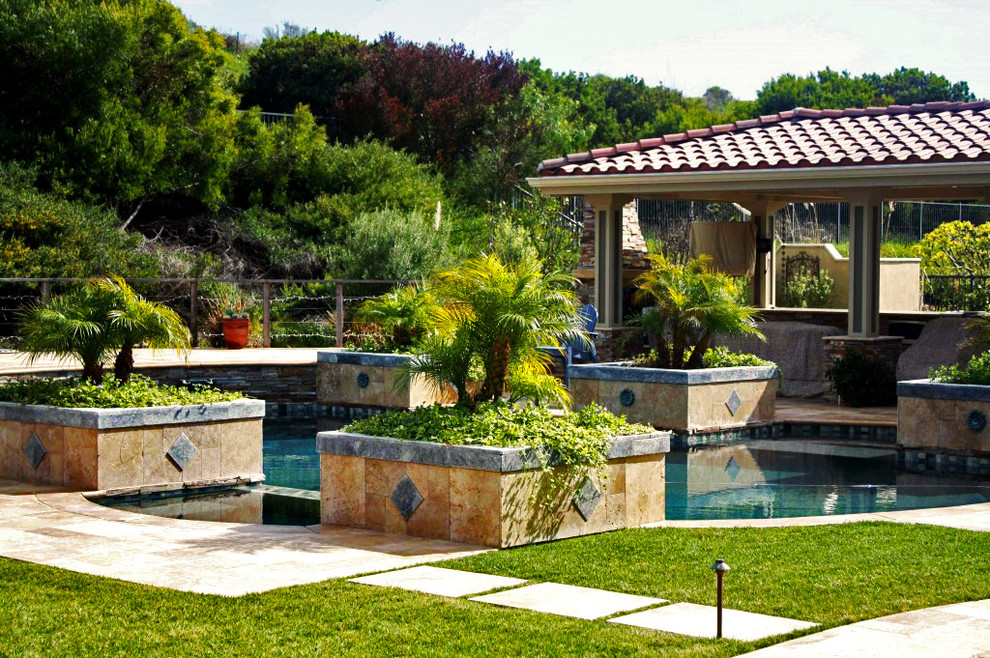 На фото: бассейн среднего размера, произвольной формы на заднем дворе в средиземноморском стиле с домиком у бассейна и покрытием из плитки с