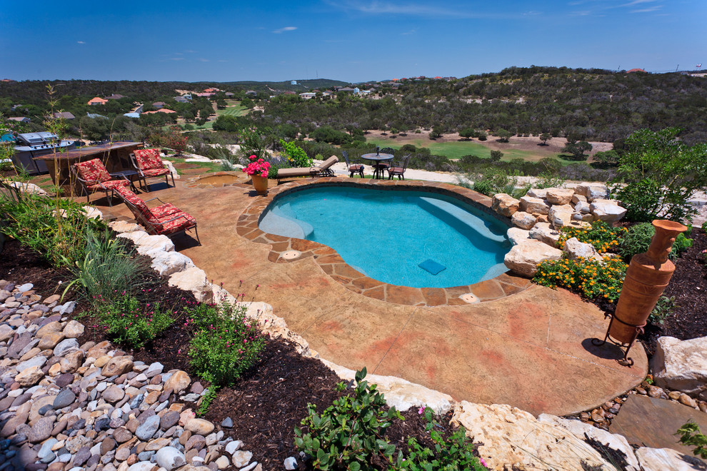 Ejemplo de piscina con fuente natural rural de tamaño medio a medida en patio trasero con losas de hormigón