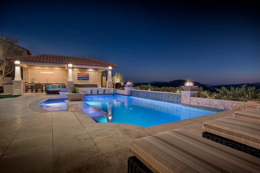 На фото: большой бассейн произвольной формы на заднем дворе в средиземноморском стиле с фонтаном и покрытием из каменной брусчатки с