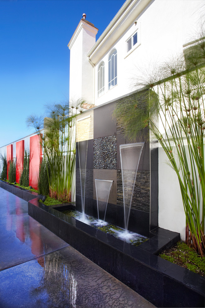 Foto di una piscina monocorsia minimalista rettangolare di medie dimensioni e dietro casa con fontane