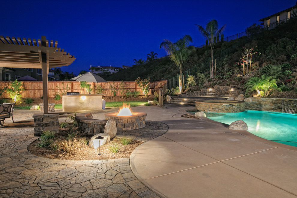 Example of a mid-sized tuscan backyard concrete paver pool design in San Diego