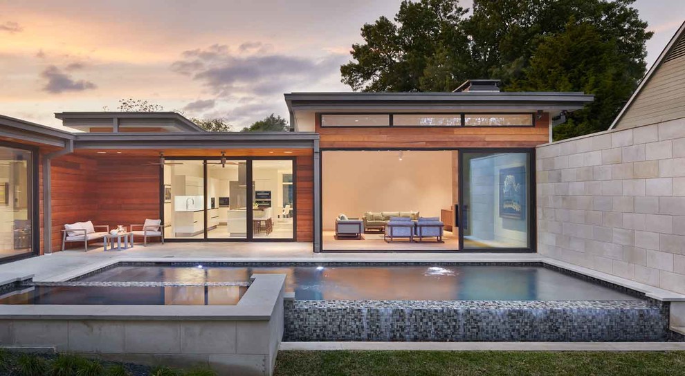 Diseño de piscinas y jacuzzis infinitos contemporáneos rectangulares en patio trasero con losas de hormigón