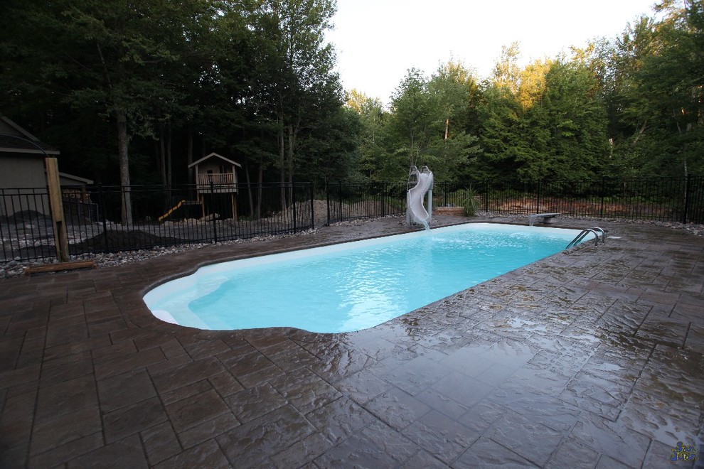 Pool - mid-sized traditional backyard stamped concrete and rectangular pool idea in Other
