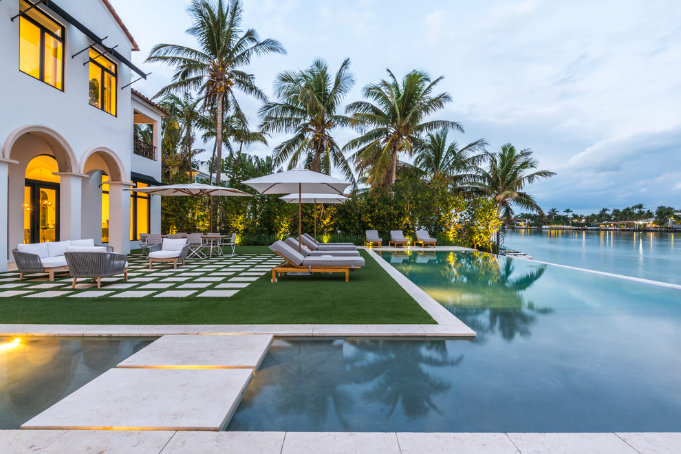 Imagen de piscina infinita minimalista grande en forma de L en patio trasero