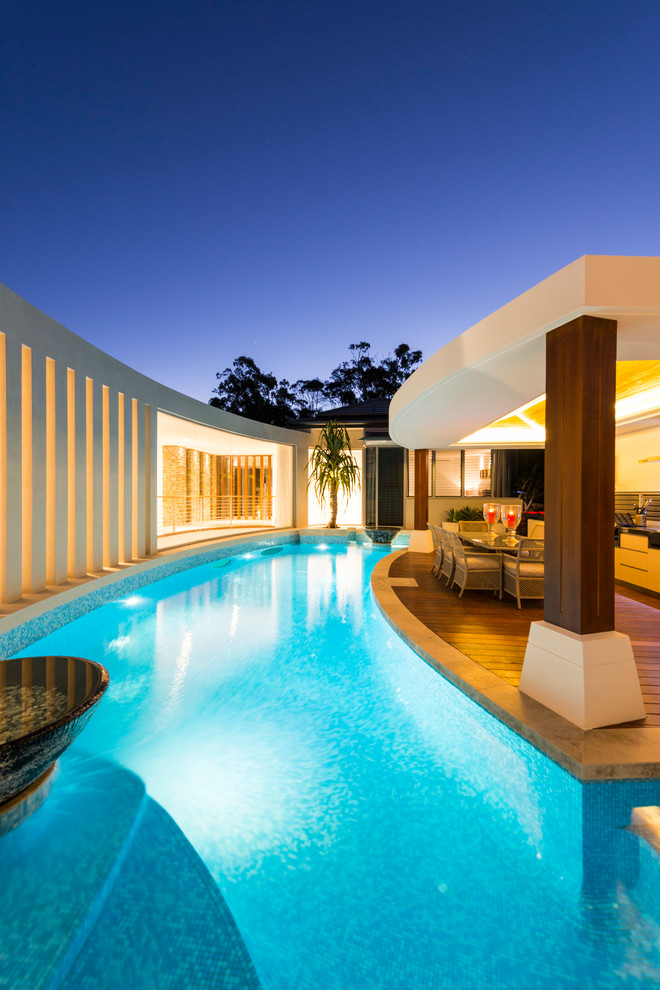 Свежая идея для дизайна: бассейн произвольной формы на заднем дворе в современном стиле с домиком у бассейна и настилом - отличное фото интерьера