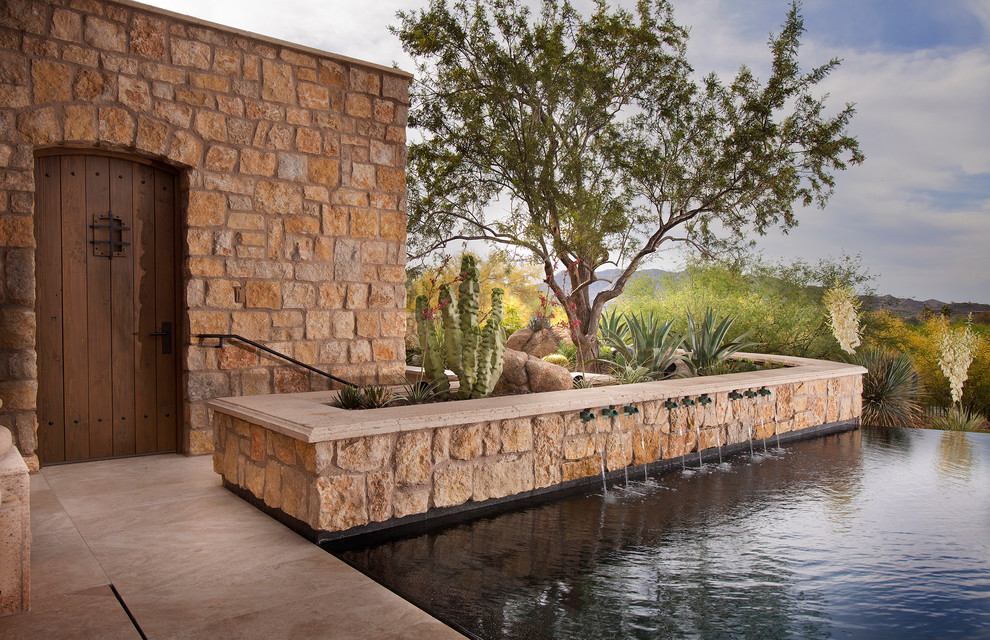 Contemporary infinity swimming pool in Phoenix with a water feature.