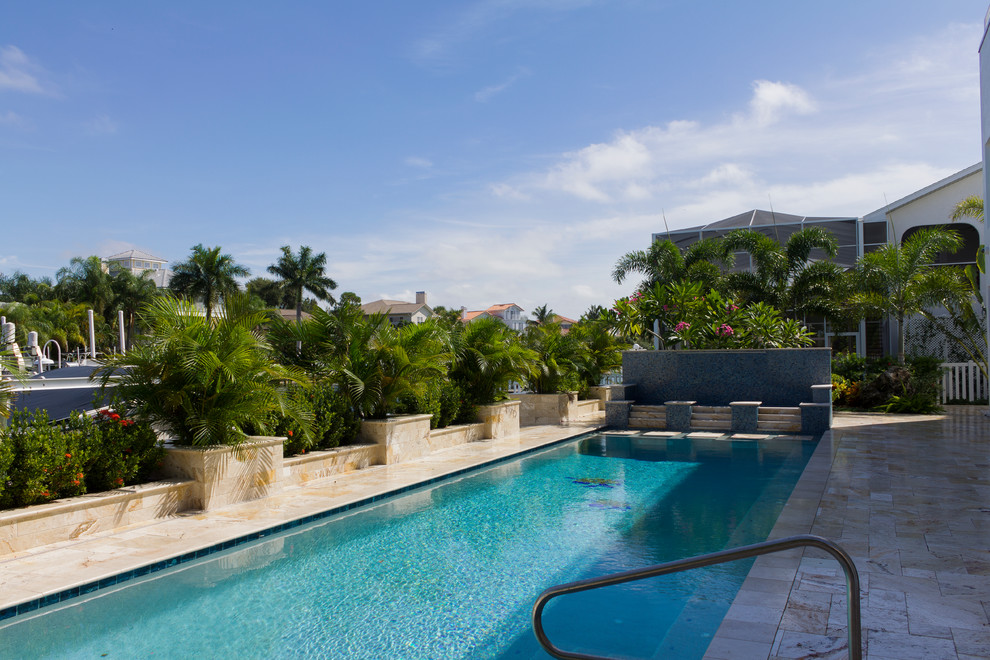 Mittelgroßer Moderner Schwimmteich hinter dem Haus in rechteckiger Form mit Natursteinplatten in Tampa
