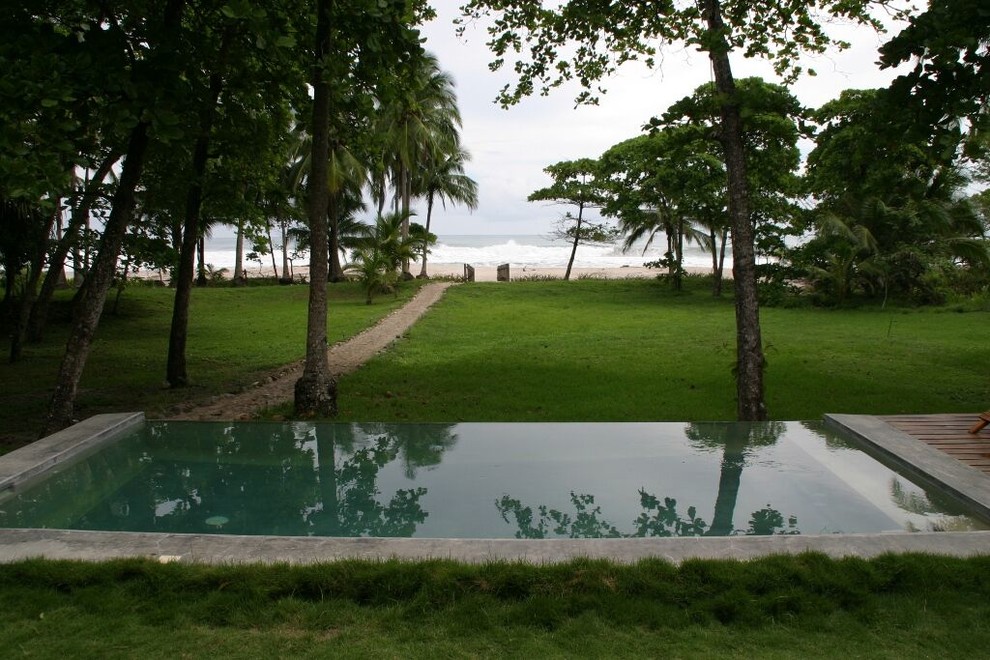 Ispirazione per una piccola piscina a sfioro infinito costiera rettangolare dietro casa con pedane