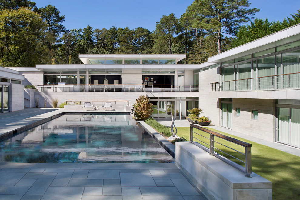 Ejemplo de piscinas y jacuzzis naturales retro grandes rectangulares en patio trasero con adoquines de piedra natural