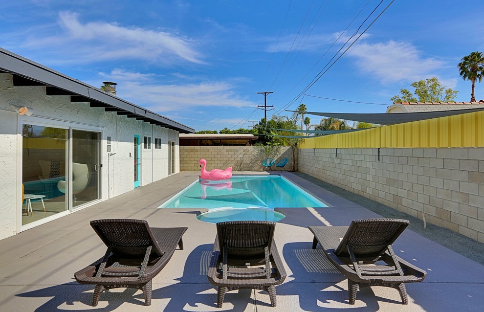 Foto de piscinas y jacuzzis alargados vintage grandes rectangulares en patio trasero con losas de hormigón