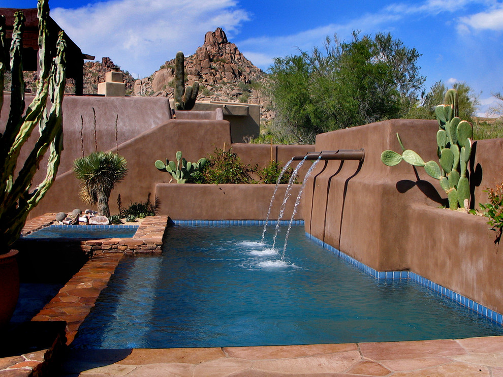 Diseño de piscinas y jacuzzis infinitos de estilo americano de tamaño medio rectangulares en patio trasero con adoquines de piedra natural