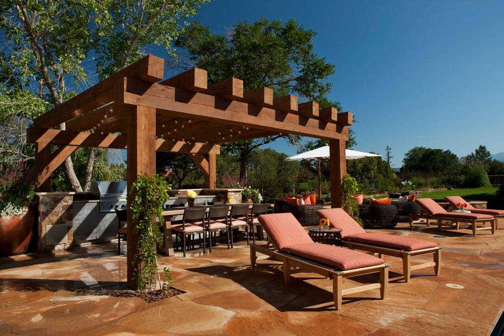 Imagen de piscina natural rústica grande rectangular en patio trasero con adoquines de piedra natural