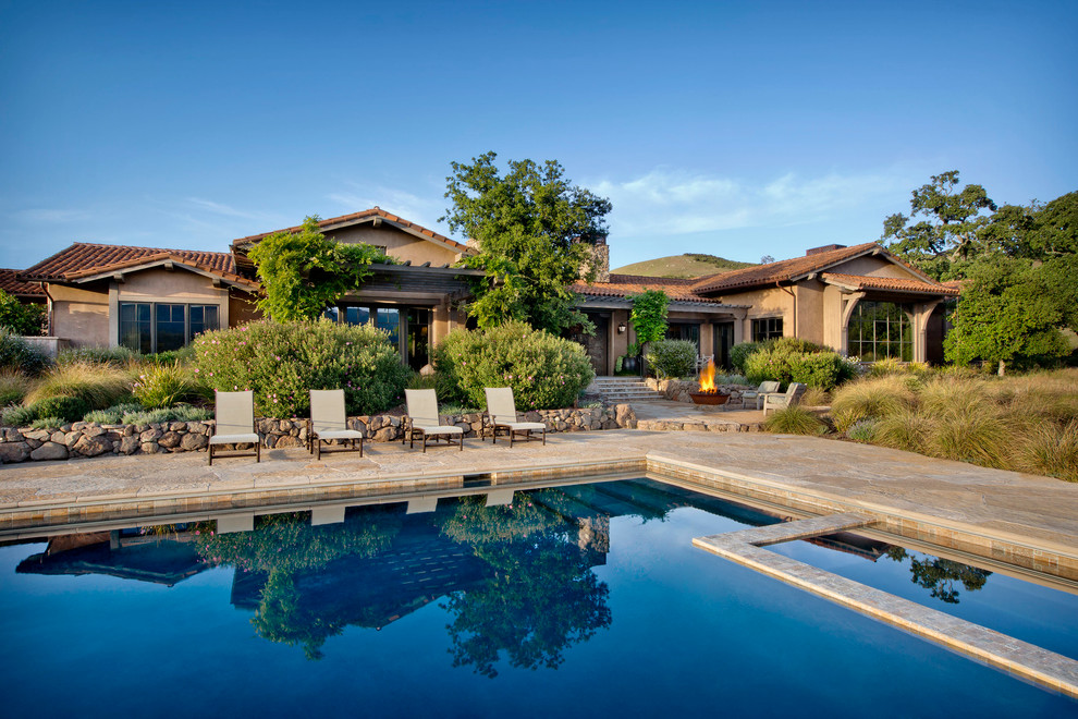 Imagen de piscinas y jacuzzis alargados de estilo americano extra grandes rectangulares en patio trasero con adoquines de piedra natural