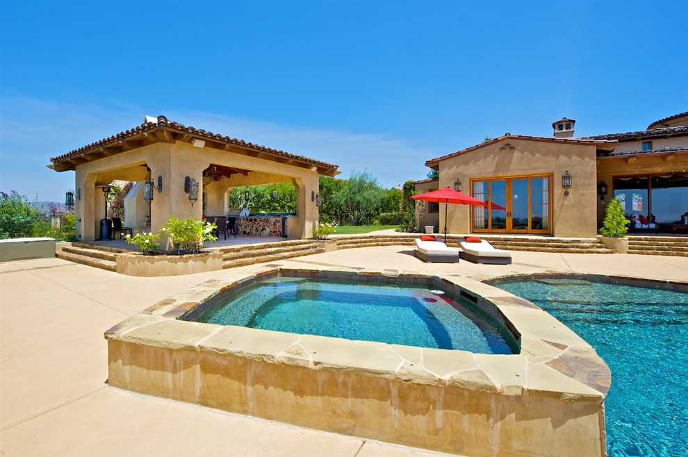 Idee per un'ampia piscina a sfioro infinito mediterranea personalizzata dietro casa con un acquascivolo