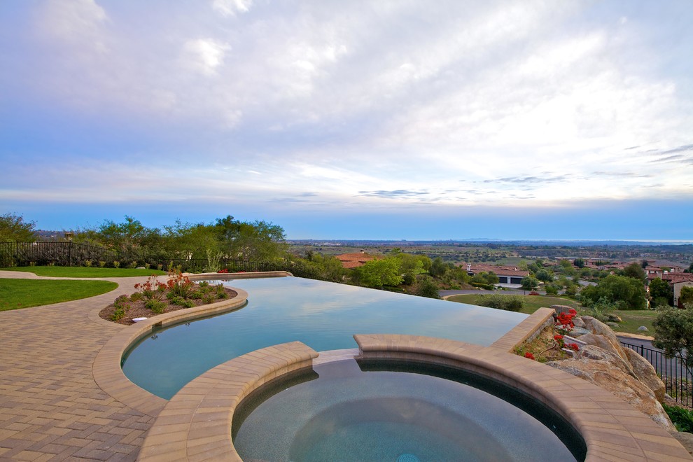 Inspiration for a mediterranean back custom shaped infinity swimming pool in San Diego.