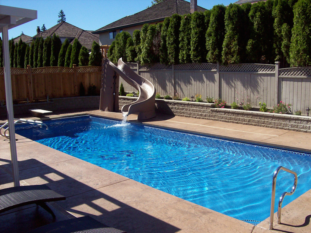 Water slide - mid-sized traditional side yard stamped concrete and rectangular water slide idea in New York