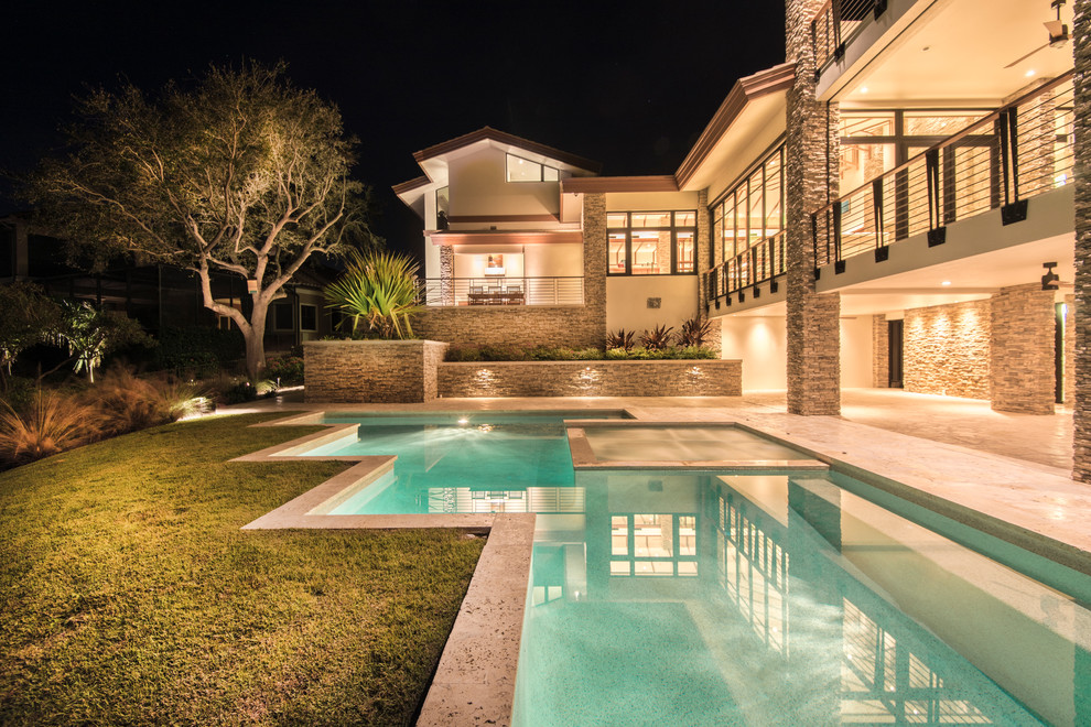 Foto di una piscina naturale minimalista personalizzata di medie dimensioni e dietro casa con una vasca idromassaggio e pavimentazioni in pietra naturale