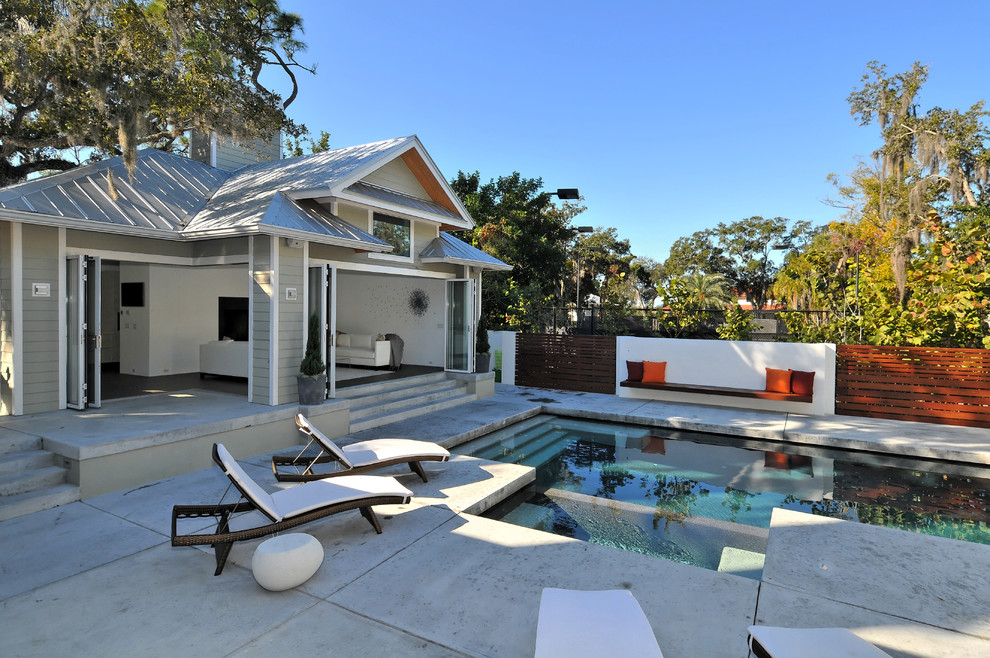 Großer Moderner Pool hinter dem Haus in rechteckiger Form mit Betonplatten in Tampa