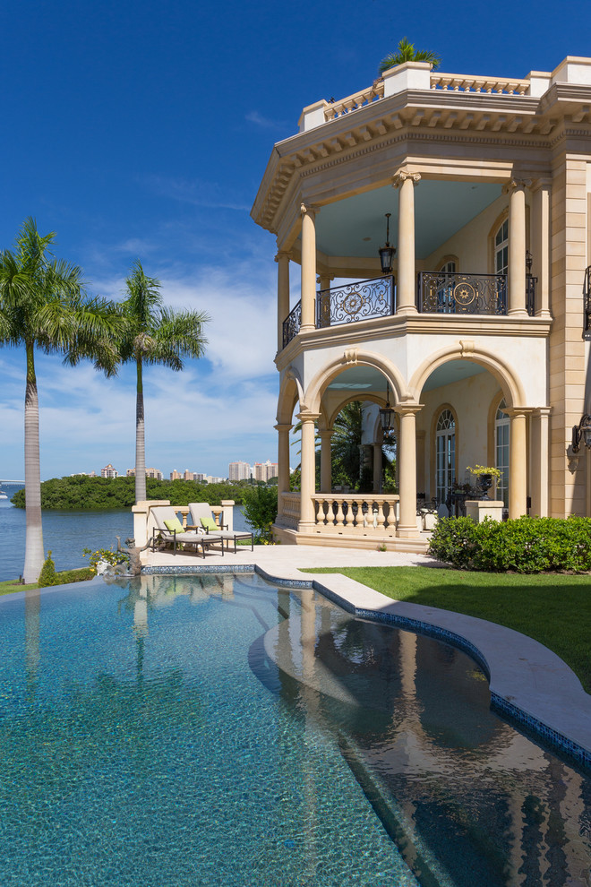 Inspiration for an expansive mediterranean back infinity swimming pool in Tampa with tiled flooring.