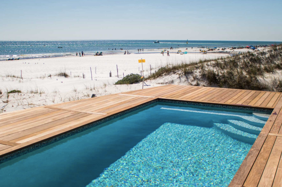 Foto di una piscina monocorsia costiera rettangolare di medie dimensioni e dietro casa con pedane