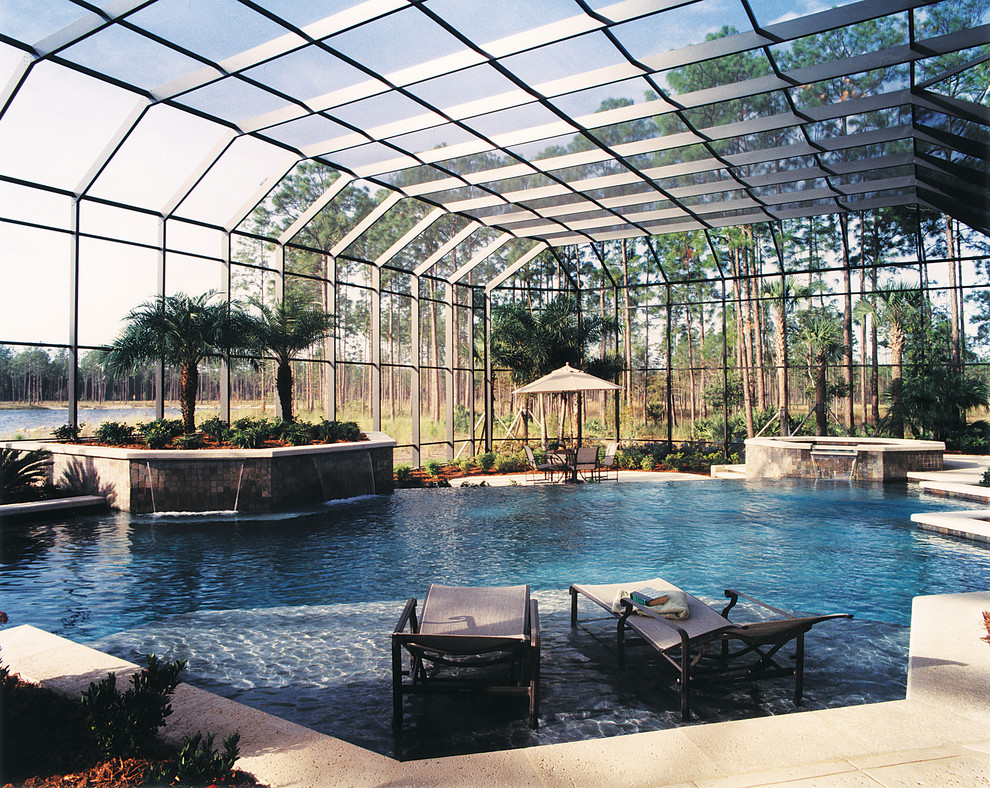 Foto på en mycket stor tropisk pool på baksidan av huset, med en fontän och naturstensplattor