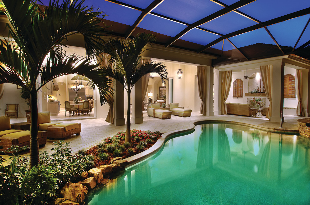 Large tuscan backyard concrete paver and custom-shaped lap hot tub photo in Miami