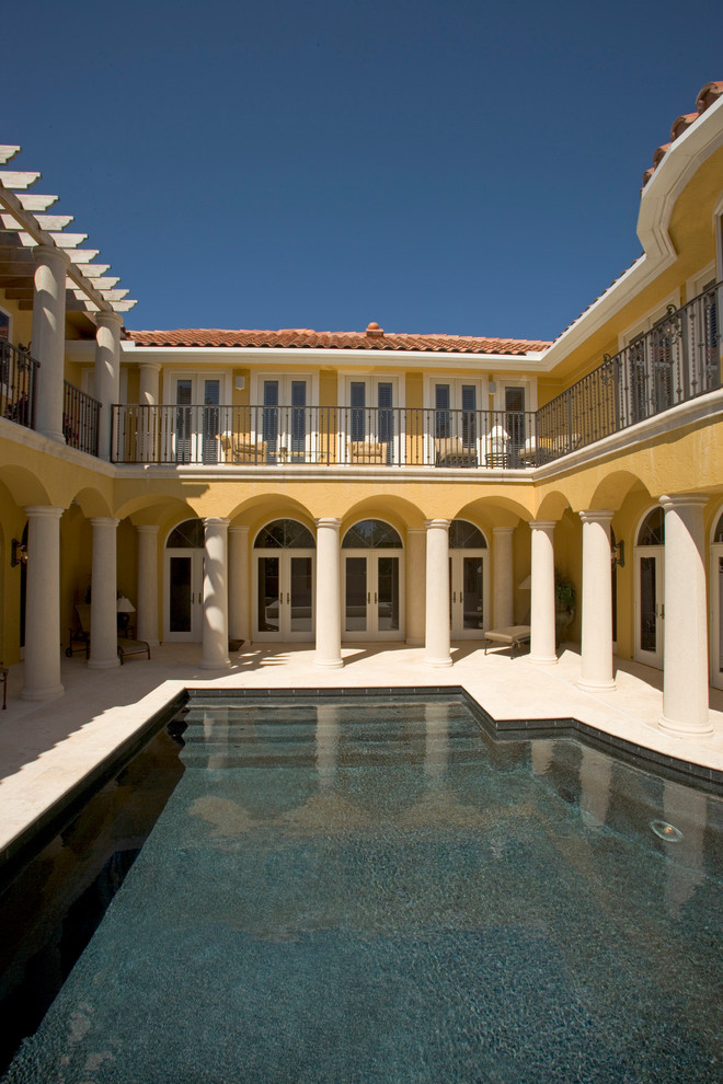 Example of a tuscan courtyard custom-shaped pool design in Miami