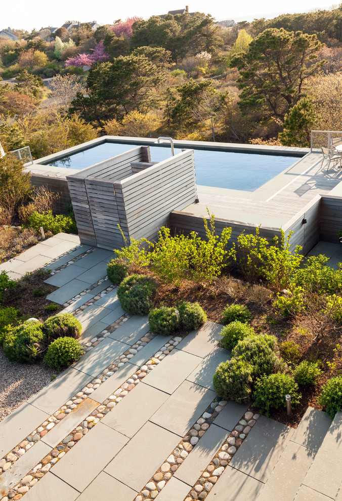 Idee per una grande piscina fuori terra contemporanea rettangolare dietro casa con fontane e pedane