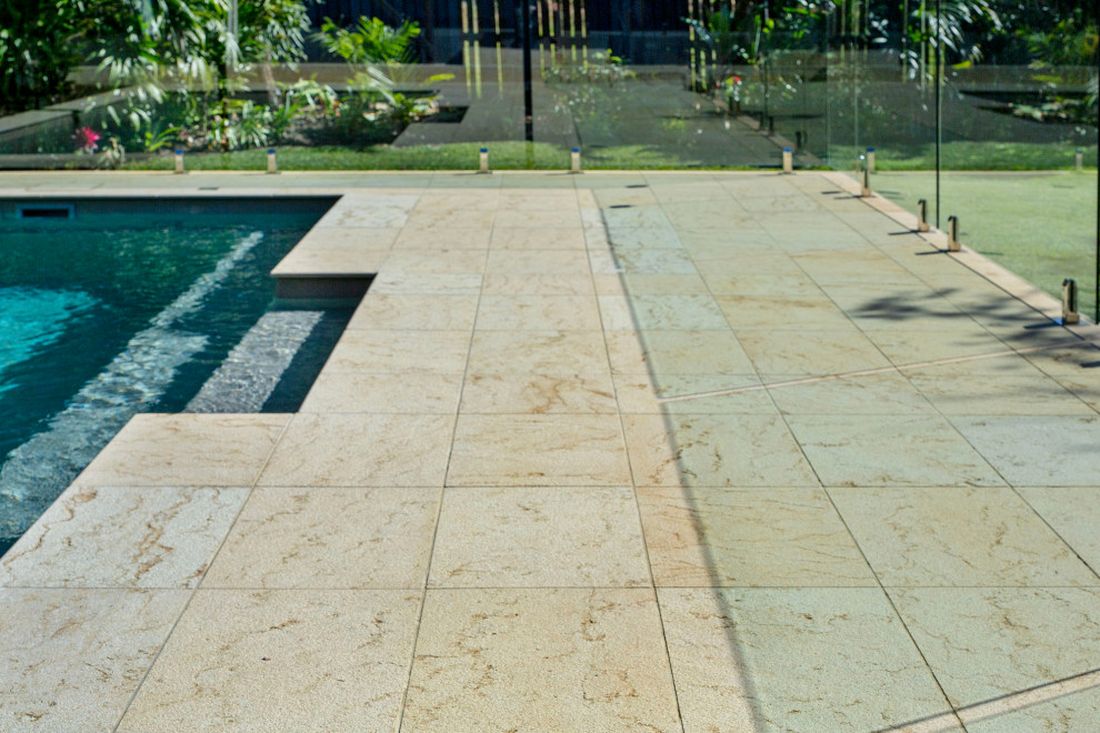 Imagen de piscina alargada costera de tamaño medio rectangular en patio trasero con paisajismo de piscina y adoquines de piedra natural
