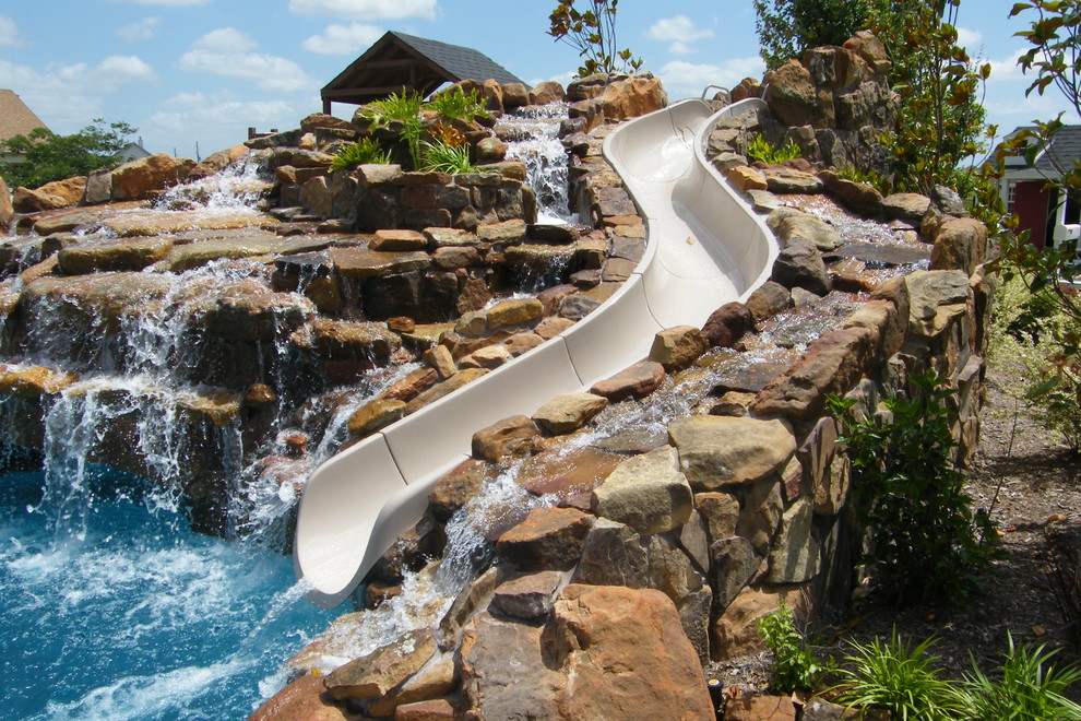 Ispirazione per una grande piscina stile rurale personalizzata dietro casa con un acquascivolo e cemento stampato