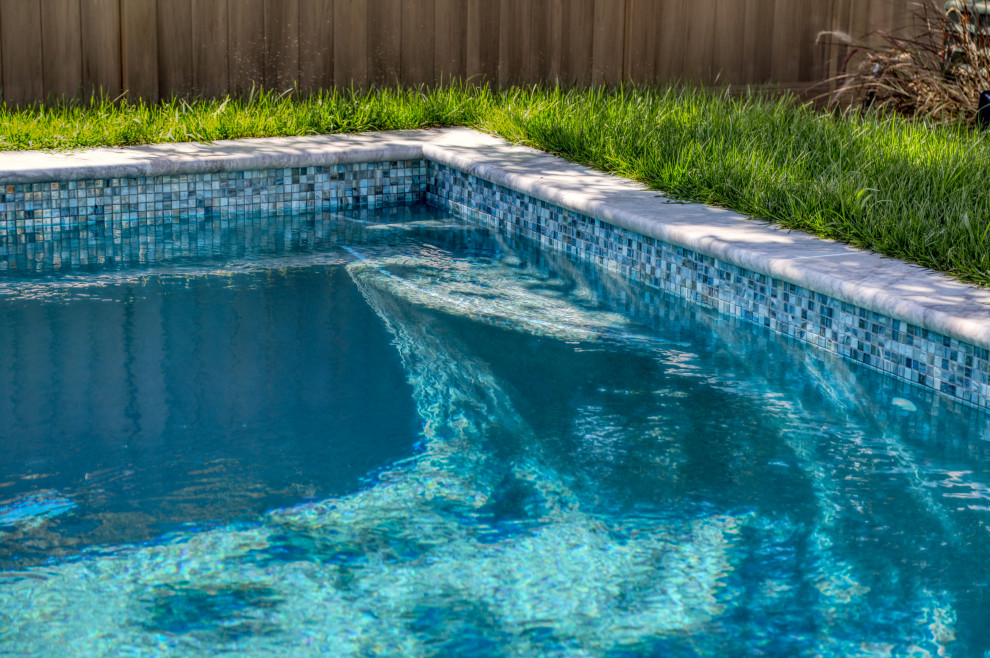 Example of a small classic backyard stone and rectangular pool design in Other
