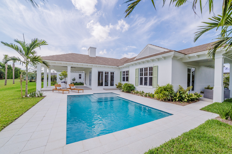 This is an example of a contemporary back rectangular swimming pool in Miami with stamped concrete.