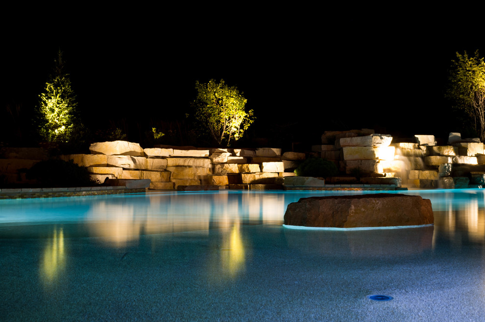 Пример оригинального дизайна: огромный естественный бассейн произвольной формы на заднем дворе в стиле модернизм с фонтаном и покрытием из каменной брусчатки