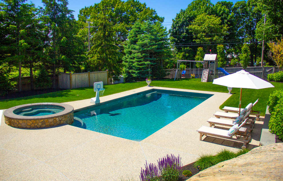 Idee per una grande piscina naturale contemporanea rettangolare dietro casa con una vasca idromassaggio e pedane