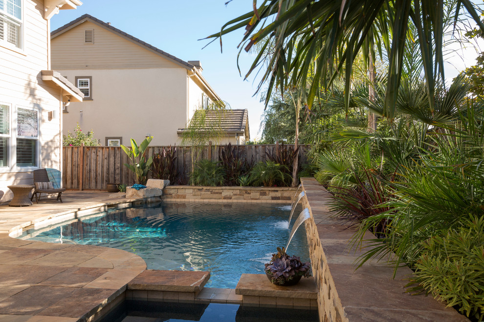 Idee per una grande piscina mediterranea rotonda dietro casa con una vasca idromassaggio e pavimentazioni in pietra naturale