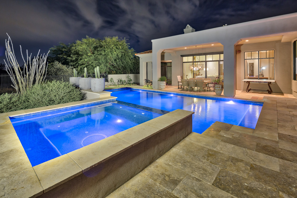 Ejemplo de piscina natural contemporánea grande rectangular en patio trasero con adoquines de hormigón