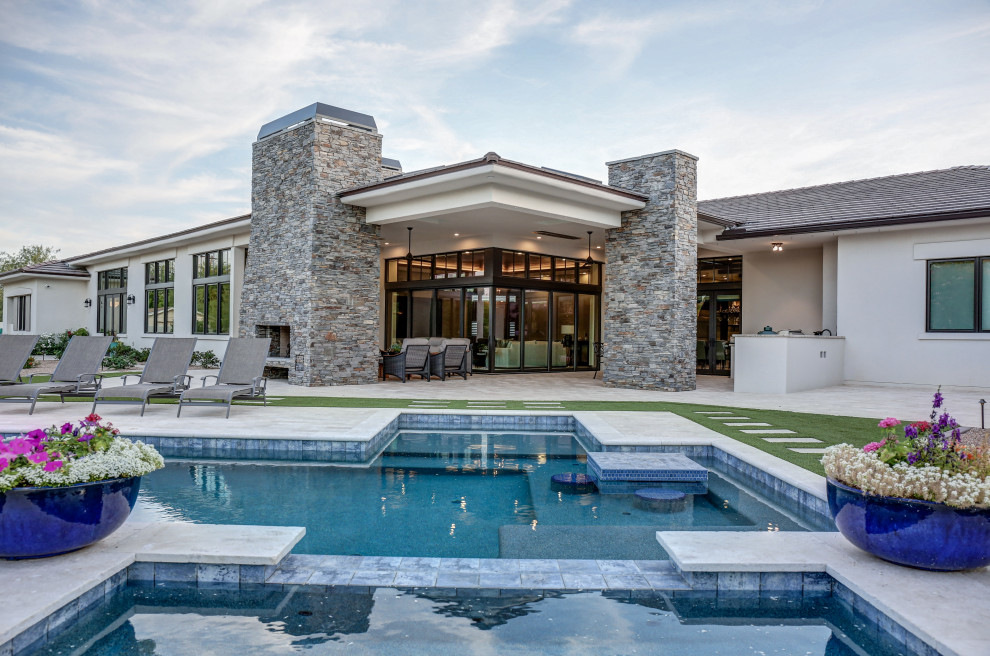Immagine di una grande piscina a sfioro infinito classica personalizzata dietro casa con una vasca idromassaggio e cemento stampato