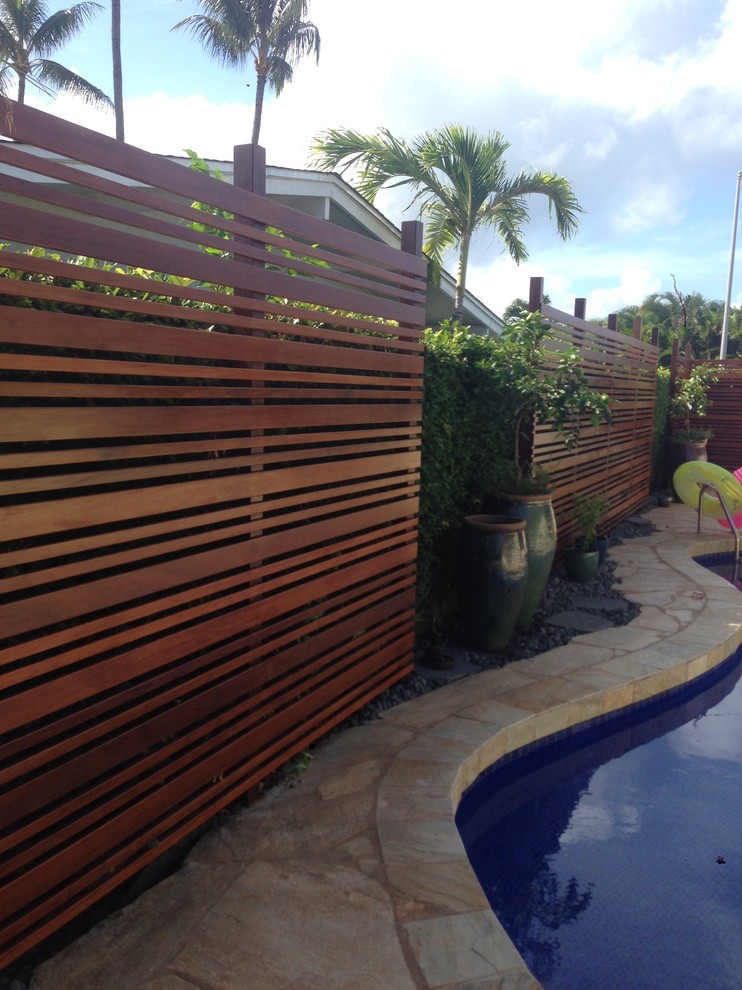 Medium sized world-inspired back kidney-shaped lengths swimming pool in Hawaii with natural stone paving.