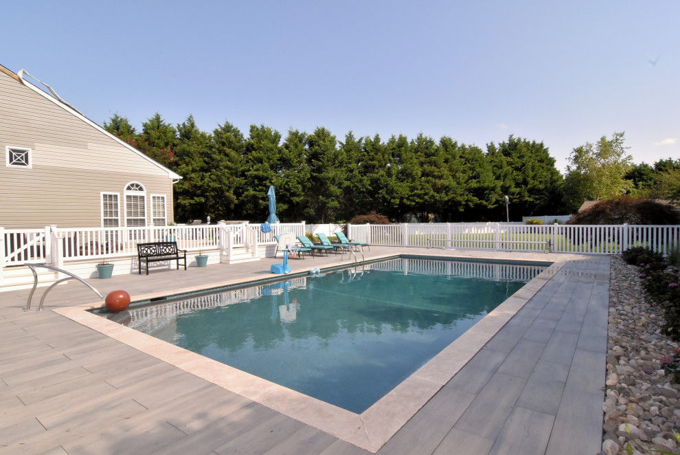 Cette image montre une grande piscine latérale traditionnelle rectangle avec du carrelage.
