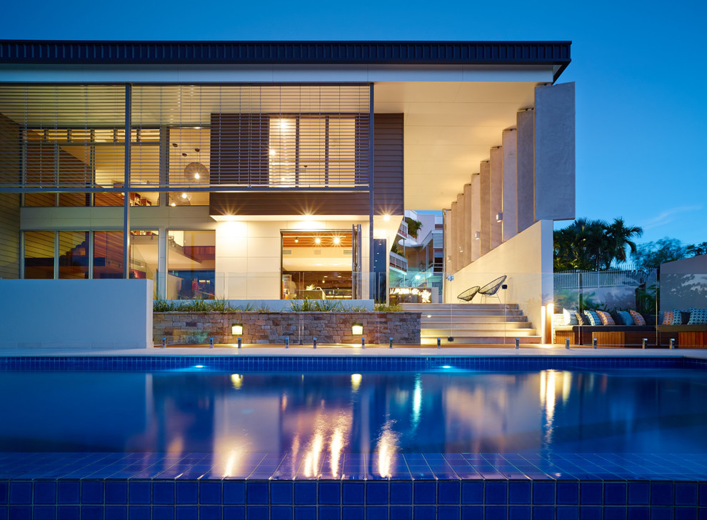 Immagine di una grande piscina monocorsia minimal rettangolare davanti casa con pavimentazioni in pietra naturale
