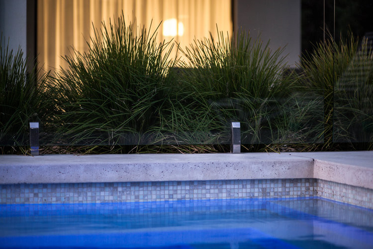 Photo of a large retro back rectangular swimming pool in Melbourne with concrete slabs.